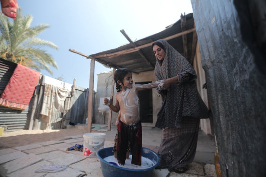 The Mother Bathes Her Child Under the Sky of Gaza