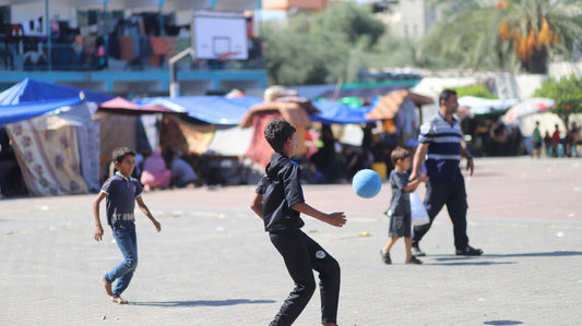 Two Children Play Football in Displacement Camp
